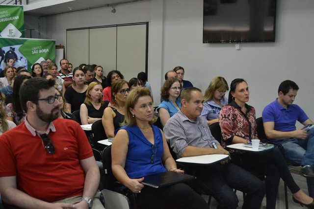 Foto mostra servidores da reitoria sentados no auditório